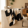 Weir cozy throw blanket draped over a linen sofa in a warm neutral living room