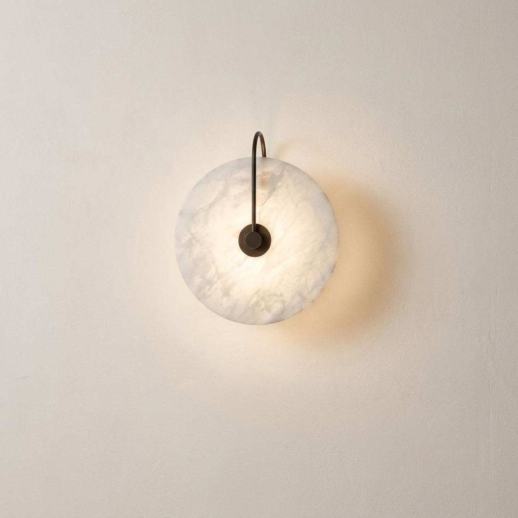 Teasel marble wall sconce lit on a warm plaster interior wall