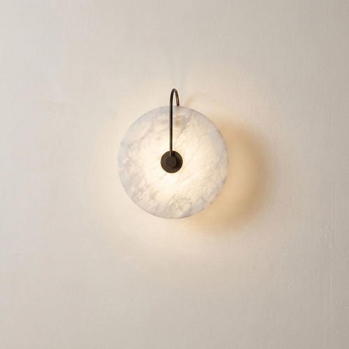 Teasel marble wall sconce lit on a warm plaster interior wall