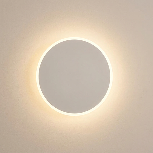 Amble wall light casting a soft wash of light on a plaster wall