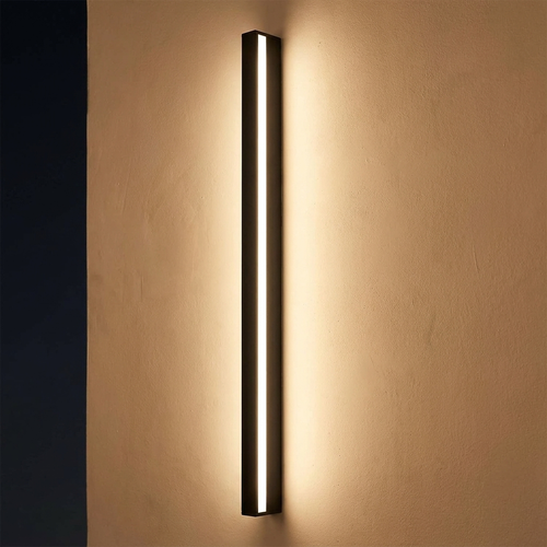 Hoy wall light close view lit at night on a plaster wall