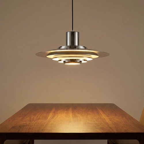 Metal chandelier lit above a walnut dining table