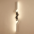 Reef wall sconce lit on a warm plaster interior wall